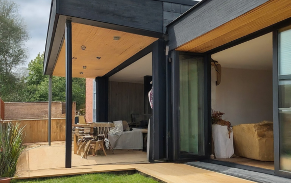 Modern home addition featuring a spacious outdoor deck, stylish wooden accents, and a contemporary open-plan interior, illustrating functional living space for Michigan homeowners.