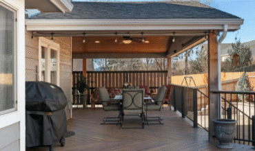Home addition featuring an outdoor deck with seating area, grill, and covered roof, enhancing living space for Michigan homes.